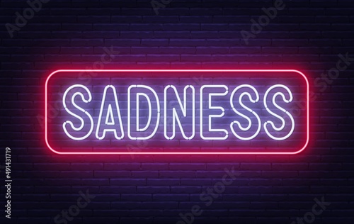 Neon sign Sadness on brick wall background.