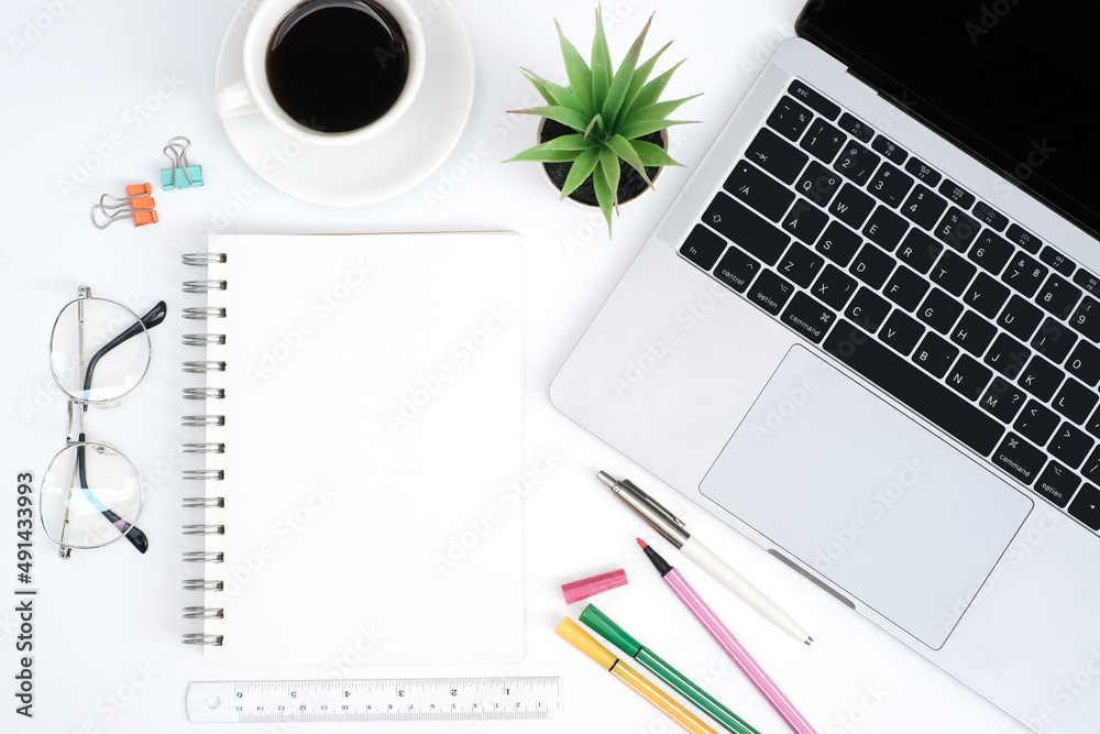 Work form home or online learning concept on white table desk with blank notepad and laptop computer with stationery, social distance during quarantine, self-isolation, online education concept Work form home or online learning concept on white table desk with blank notepad and laptop computer with stationery, social distance during quarantine, self-isolation, online education concept