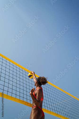 Woman with afro hair playing beach volleyball