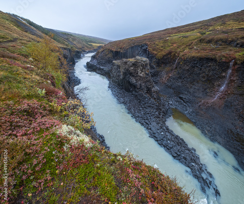 Autumn  picturesque Studlagil canyon is a ravine in Jokuldalur, Eastern Iceland. Famous columnar basalt rock formations and Jokla river runs through it. photo