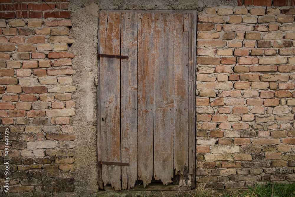 Naklejka premium Sunja, Croatia, 05,04,2021: Old wooden rustic doors on rural home wall.
