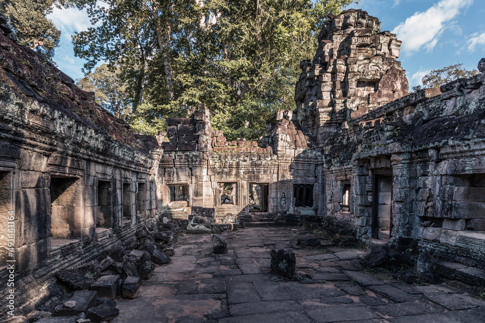 Сourtyard of ancient Cambodian temple among trees in Angkor complex, Siem Reap, Cambodia