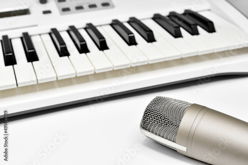 Photography Professional studio microphone against blurred synthesizer keyboard background