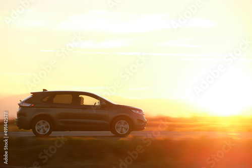 SUV car driving fast on intercity road at sunset. Highway traffic in evening © bilanol