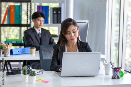 Portrait of Asian beautiful business woman working at the office, using computer on table.