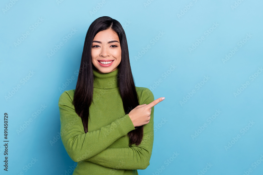 Photo of sweet millennial brunette lady index promo wear green pullover isolated on blue color background Photo of sweet millennial brunette lady index promo wear green pullover isolated on blue color background