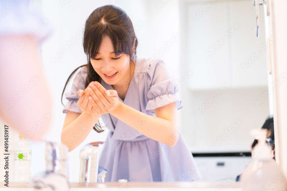 家で洗顔をする若い女性 家で洗顔をする若い女性