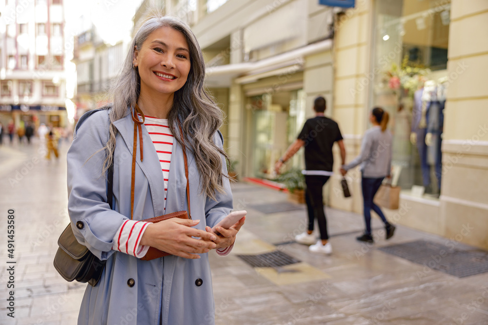 Fototapeta premium Trendy Asian woman walking outdoors in town