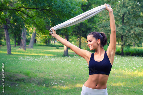 Young smiling fitness woman exercising in the summer nature