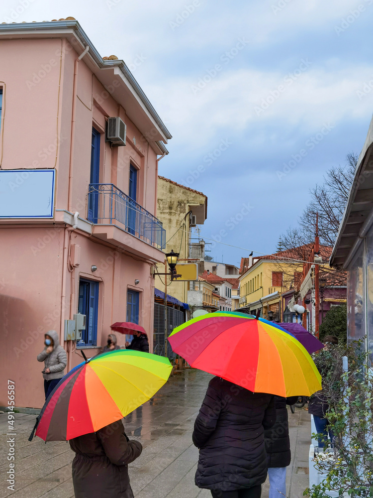 umbrellas rain weather rainbow colors in pedestrian street in a city  winter season