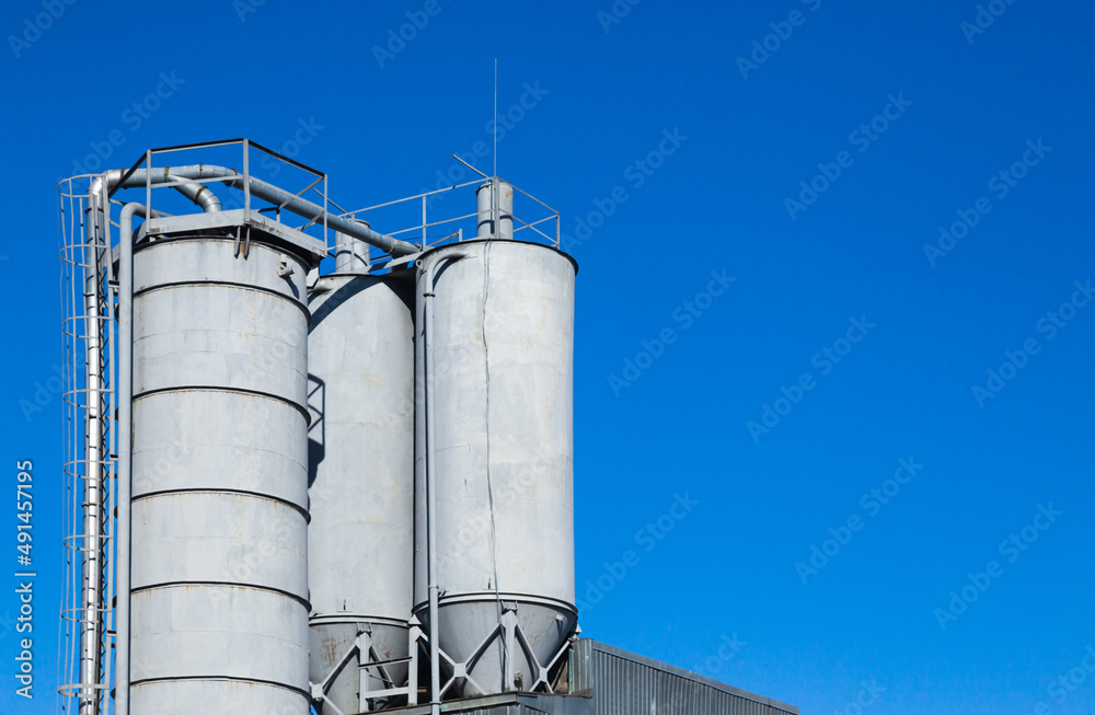 A water tower with several reservoirs and pipes approaching them.