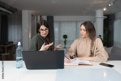 Two young woman freelancers business owners colleagues and roommates developing their online business company web site for online shopping. Creative females working on interior design project. © Srdjan