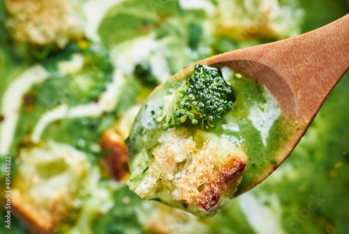 Fresh creamy broccoli soup closeup. Closeup of green healthy vegan broccoli soup in spoon. photo