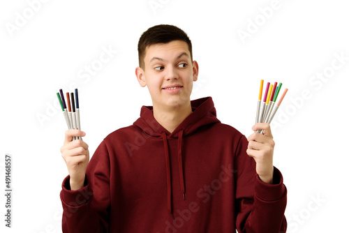 Obraz na płótnie Cheerful teenage boy facing choice between boring gray life or tempting bright. Smiling student dressed maroon hoodie, isolated on white, considering what to choose. Concept of decision-making. w salonie