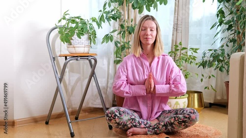 Young attractive sportive woman practicing yoga and meditation at home, indoor. Concept of calmness, relax, healthy lifestyle, wellbeing, mental development photo