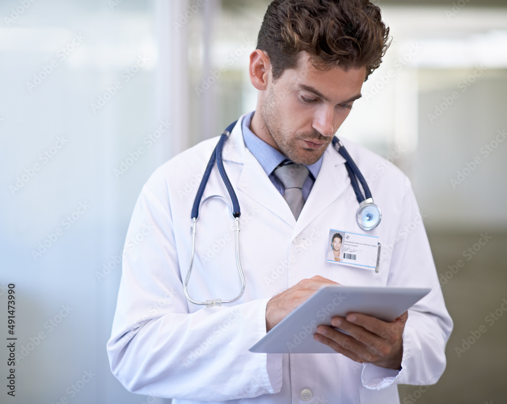 Tracking treatments with technology. Cropped shot of a handsome young doctor. Tracking treatments with technology. Cropped shot of a handsome young doctor.