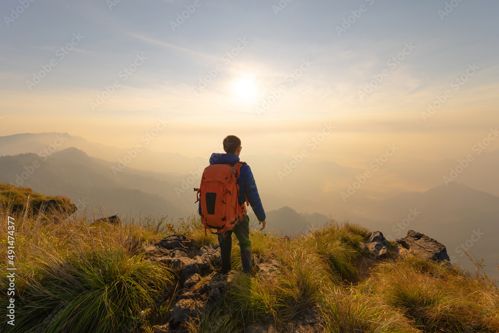 Portrait of Asian man, a tourist or backpacker, travel on green mountain hills with fog on holiday vacation. Nature landscape background, Thailand. People lifestyle.