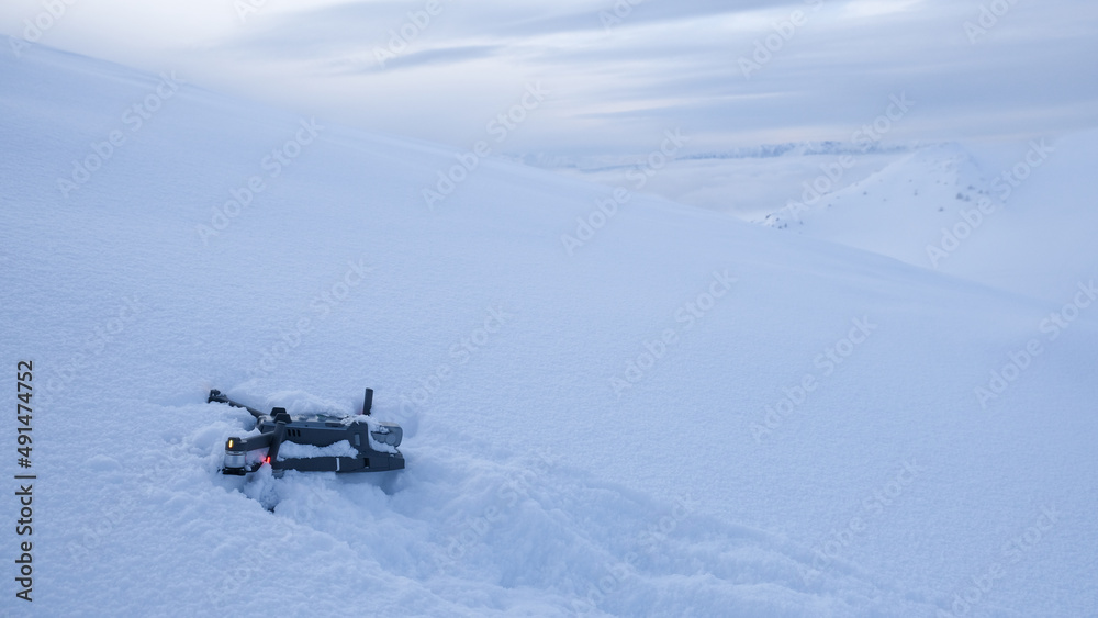 Drone crashed in the snow high up on a mountain