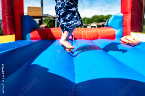Fototapeta Selective focus on foreword edge of a bouncy house with blurred children playing