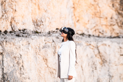 Una elegante mujer vestida con un traje blanco usando unas gafas de realidad virtual © Sergio Mena