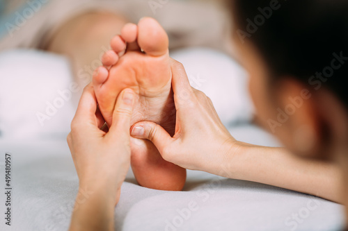 Massage im Versen Bereich am Fuß einer Frau