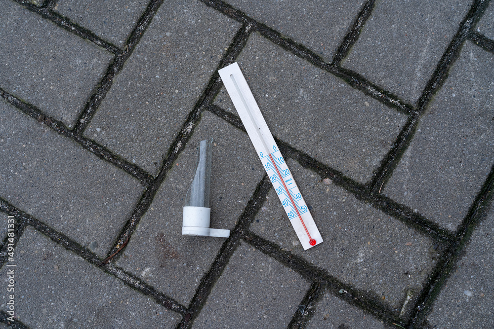 Fototapeta premium broken mercury thermometer lying on the pavement