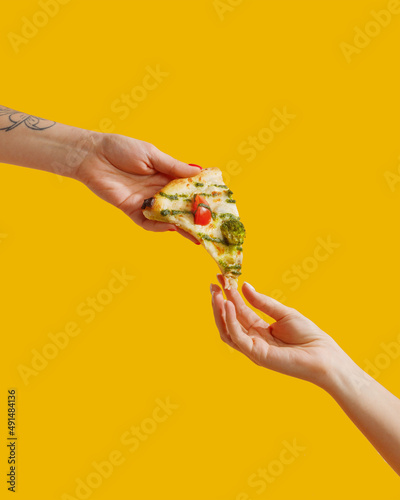 a woman's hand holds a slice of pizza