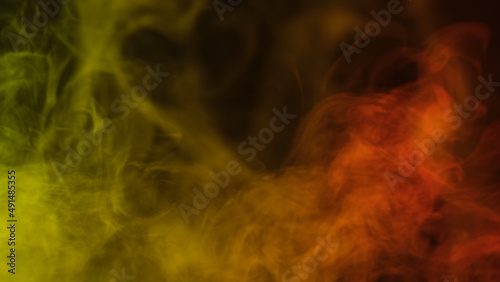 Yellow and red smoke close up on black background