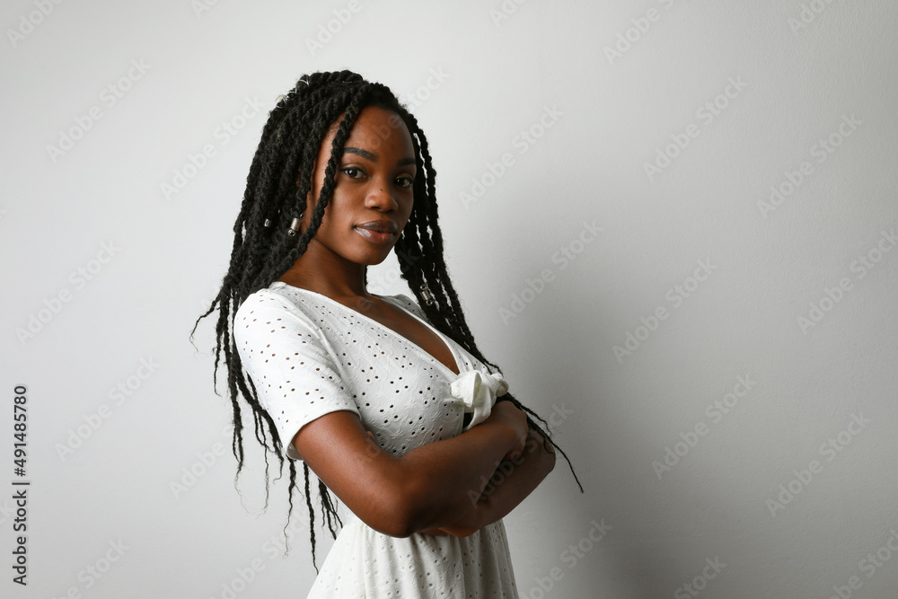 Profile photo of young African woman with long braids posing over white wall. - obrazy, fototapety, plakaty 