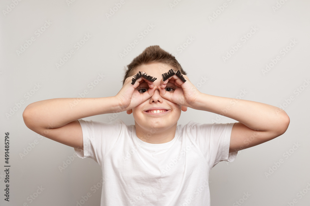 A portrait of caucasian boy with funny false eyebrows in a white T-shirt A portrait of caucasian boy with funny false eyebrows in a white T-shirt