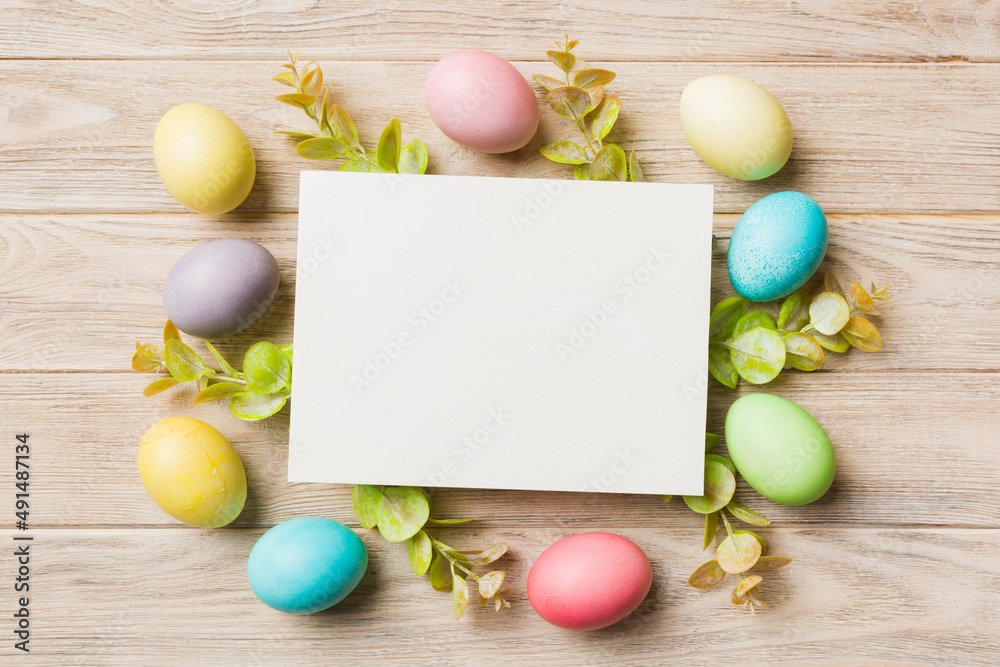 round frame multicolored Easter eggs with white blank paper on a brown background, close-up, space for text, blank for design, selective focus, tinted image round frame multicolored Easter eggs with white blank paper on a brown background, close-up, space for text, blank for design, selective focus, tinted image