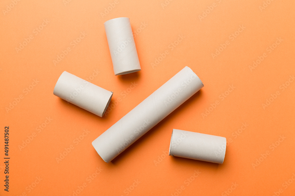 Empty toilet paper roll on colored background. Recyclable paper tube with metal plug end made of kraft paper or cardboard