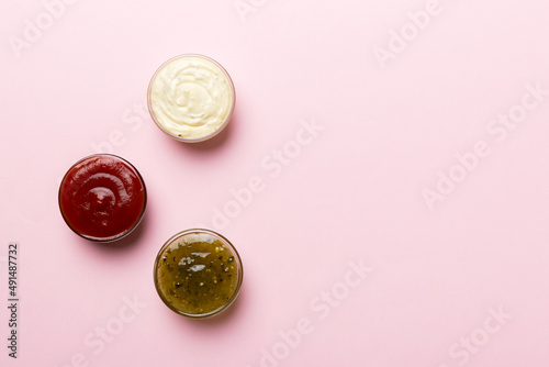 Different types of sauces in bowls on a colored Board . Top view. various sauces copy space