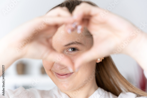 Smily young woman making heart or love sign with hands.