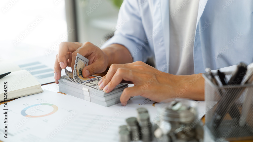 Fototapeta premium Growing savings concept. Saving money by hand putting coins money banknotes in jug glass financial accounting planning.