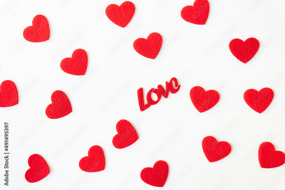 The background which consists of red hearts, the inscription love in the middle of the hearts. Love concept, greeting card for valentine's day.