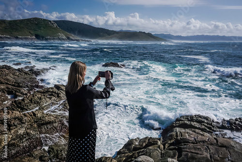 Wallpaper Mural Young and beautiful woman taking photos with the mobile on the coast of Galicia Torontodigital.ca