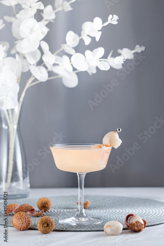 Pink Lychee Cocktail. Champagne coupe glass filled with pink lychee cocktail or mocktails surrounded by ingredients and bar tools
