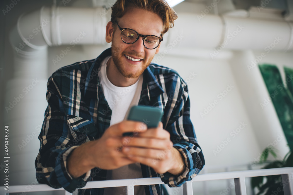 Caucasian guy use smartphone on balcony in office Caucasian guy use smartphone on balcony in office