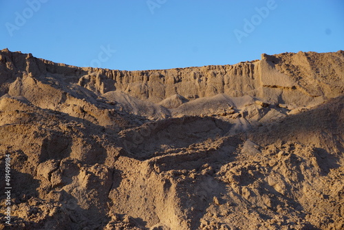 Sandberg vor Himmel bei Abendsonne im Winter 