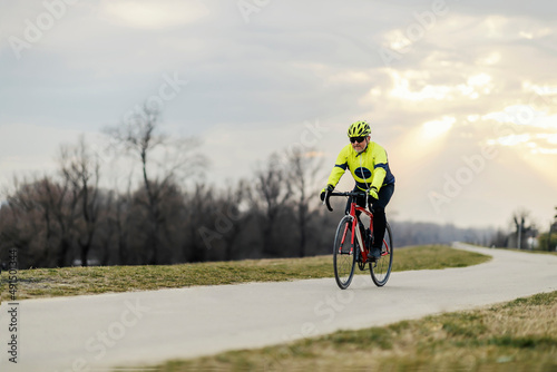 A senior bicycle rider cycling on a path in nature.