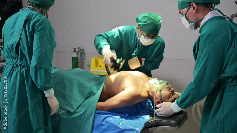 Team of doctor helping by AED defibrillation with accident injured patient unresponsive in emergency room Team of doctor helping by AED defibrillation with accident injured patient unresponsive in emergency room