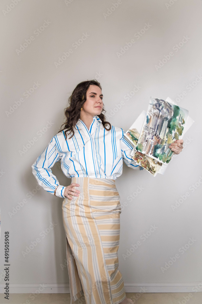 the girl holds paintings painted in watercolor the girl holds paintings painted in watercolor