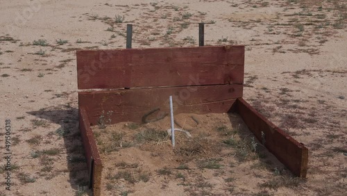 This slow motion video shows a horse shoe being thrown at it's target and missing, as it hits the desert sand. photo