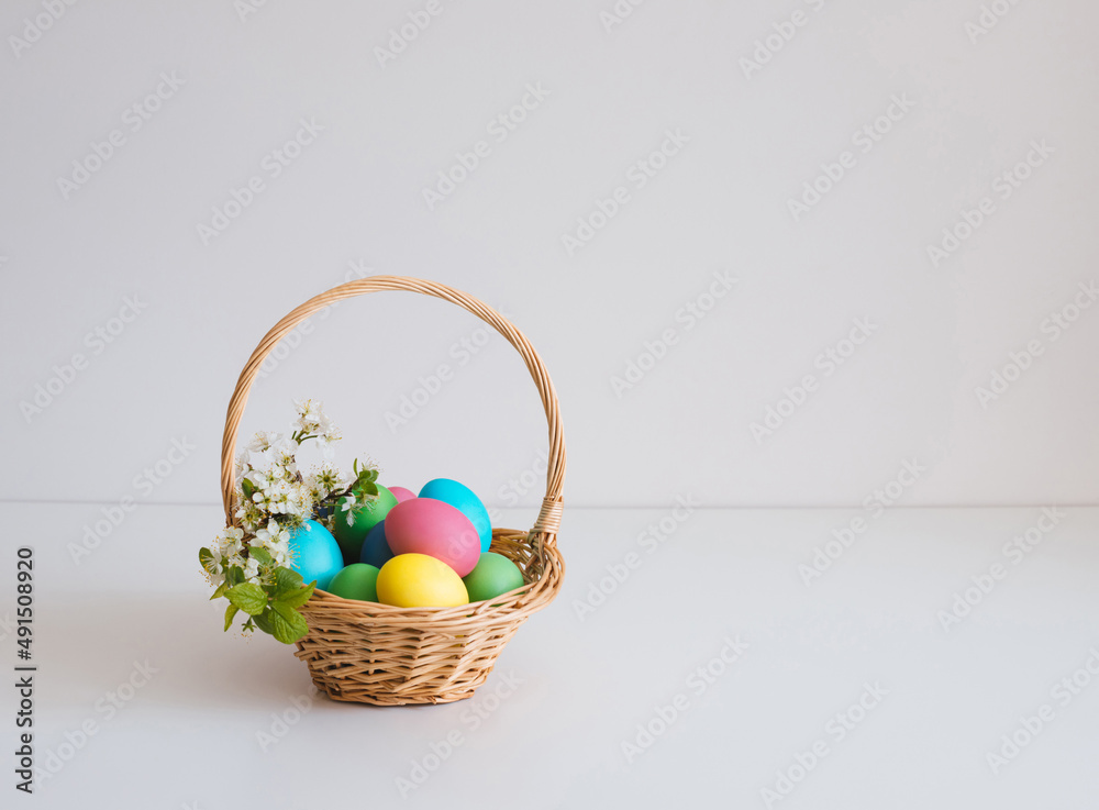 Easter basket with eggs on a white background. Beautiful Easter composition with spring flowers. Copy space. Easter basket with eggs on a white background. Beautiful Easter composition with spring flowers. Copy space.