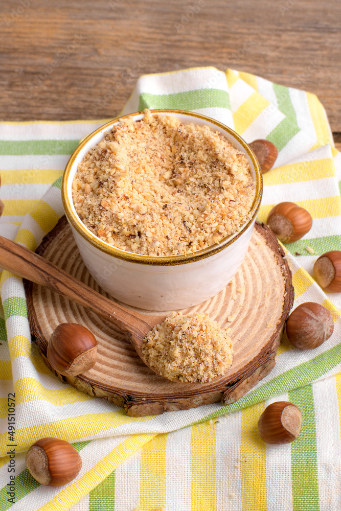 Raw Organic Ground Hazelnut Flour in a Bowl with whole nuts on rustic wooden background. Alternative nut flour for keto diet and gluten free food. Paleo and ketogenic diet baking cooking concept above Raw Organic Ground Hazelnut Flour in a Bowl with whole nuts on rustic wooden background. Alternative nut flour for keto diet and gluten free food. Paleo and ketogenic diet baking cooking concept above