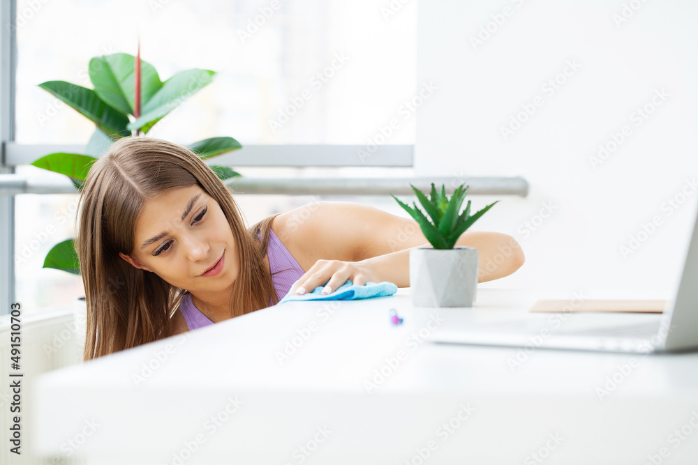 Woman wipes furniture in the office with a damp disinfectant wipe Woman wipes furniture in the office with a damp disinfectant wipe