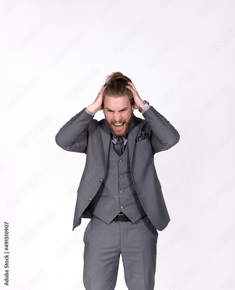 Young businessman in gray elegant suit hands on head having troubles and headache Young businessman in gray elegant suit hands on head having troubles and headache