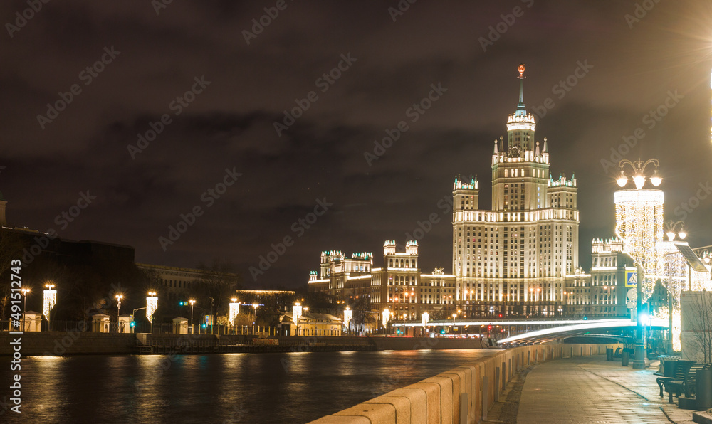 Fototapeta premium Moscow, Russia. Night view of skyscraper building at Kotelnicheskaya embankment, Shot from Raushskaya embankment. February