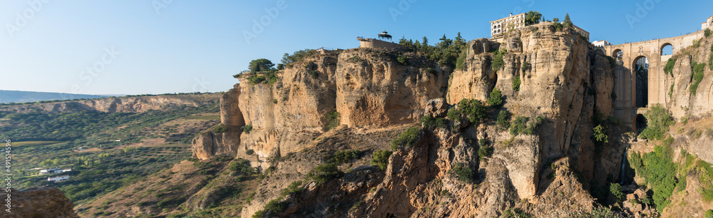 Panoramic view of Puente Nuevo (New bridge) over El Tajo gorge and the cliff in the famous white village of Ronda at daylight, Malaga province, Andalusia, Spain
